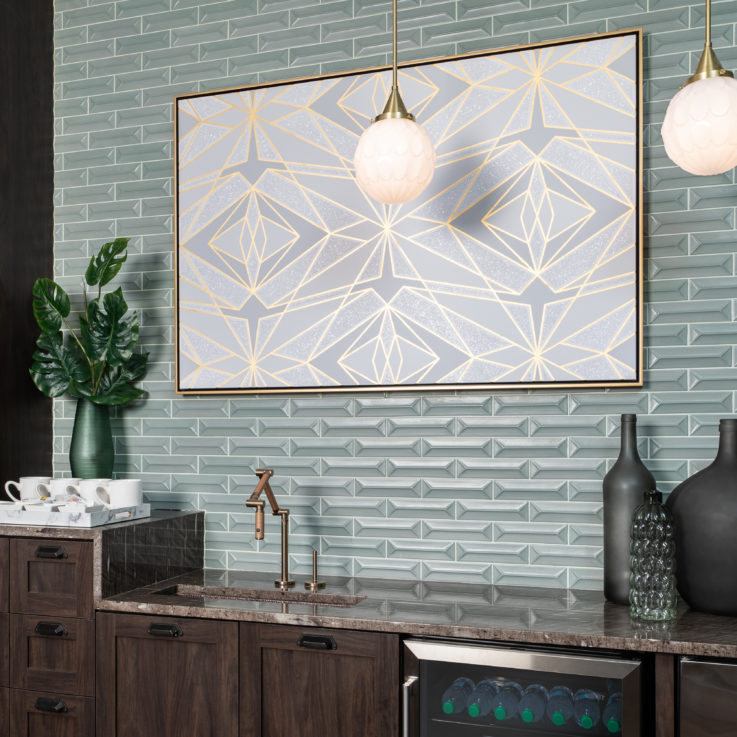 Dark cabinets with a granite countertop and a green brick wall