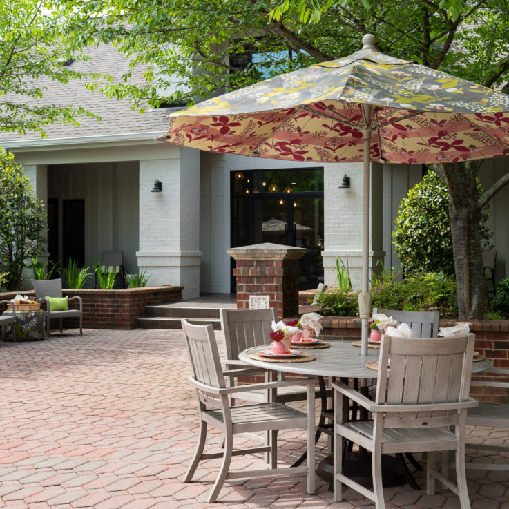 Outdoor seating area with tables and a patterned umbrella