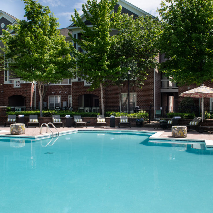 Outdoor pool with beach chairs and striped pillows