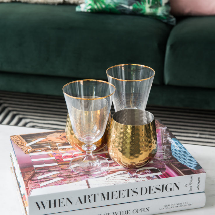 Two interior design books sitting on a coffee table with water glasses