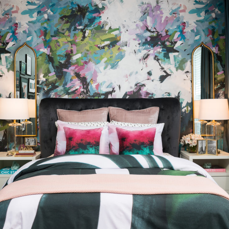 Queen bed with two nightstands against an abstract painted wall