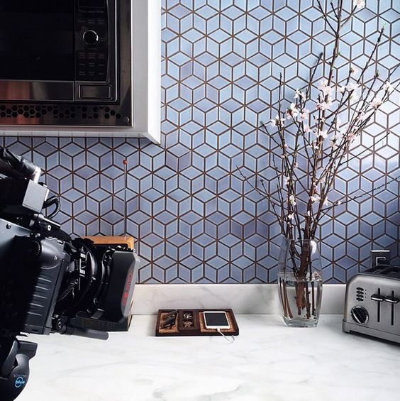 Kitchen with white countertops and light blue cube shaped tiles