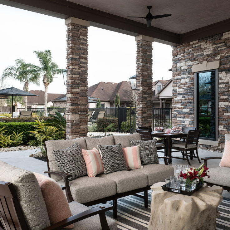 Outdoor seating with beige cushions and stone pillars