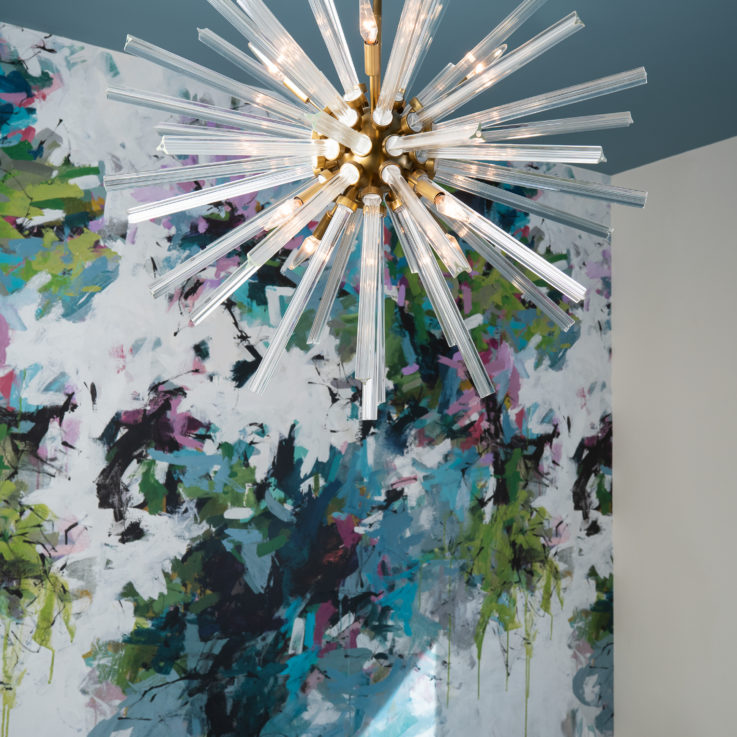 Hanging light fixture in front of an abstract mural