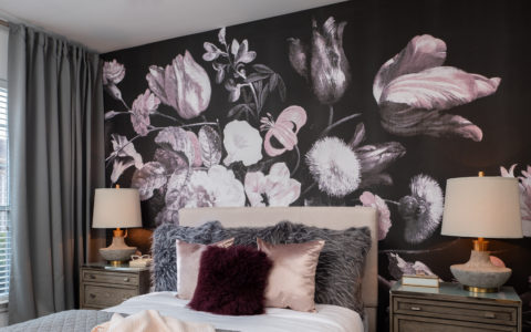 Twin bed in front of a wall with a large floral pattern