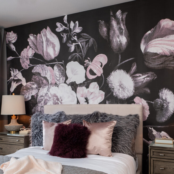 Twin bed in front of a wall with a large floral pattern