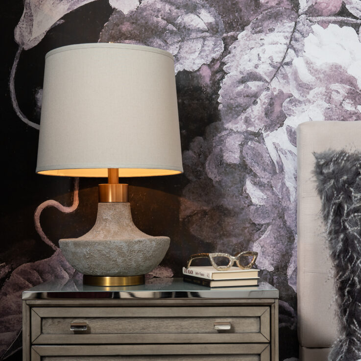 Nightstand with a lamp, books, and eyeglasses