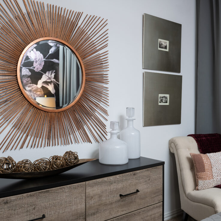 Dresser below an art sculpture and paintings