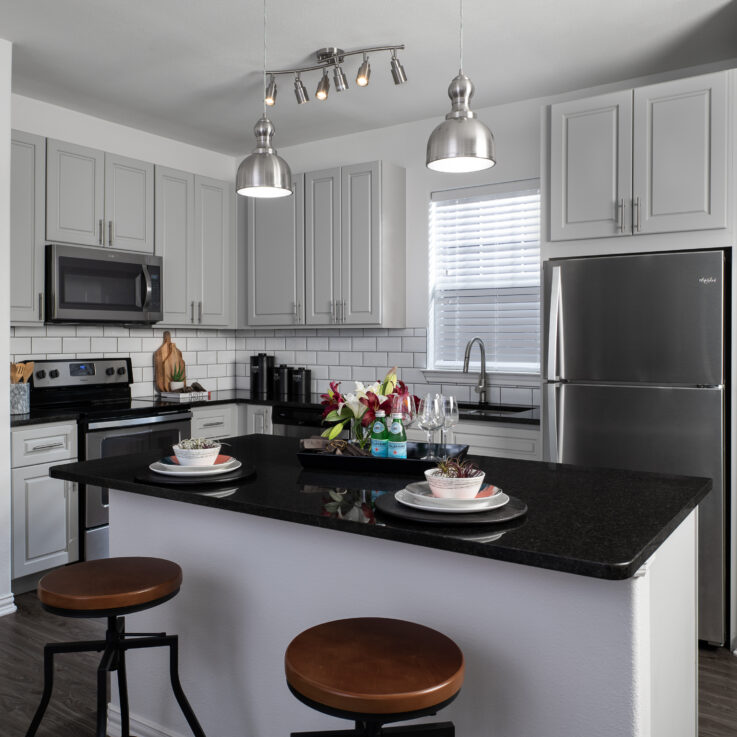 Kitchen with white cabinets, dark countertops, and stainless steel appliances