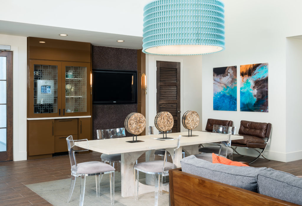 Seating area with clear chairs and artwork on the table