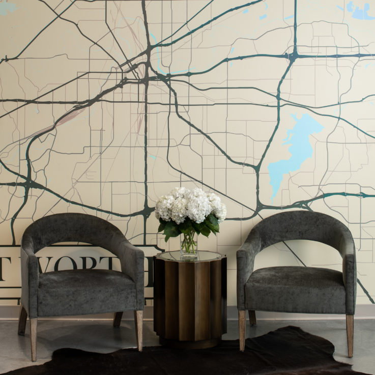 Two chairs in front of a wall painted with Dallas's map