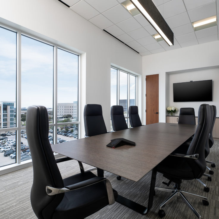 Conference room with a dark wooden table and black office chairs