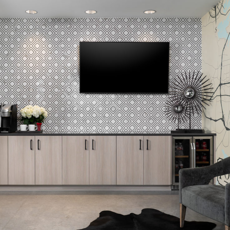 Light brown cabinets with a black countertop and coffee maker