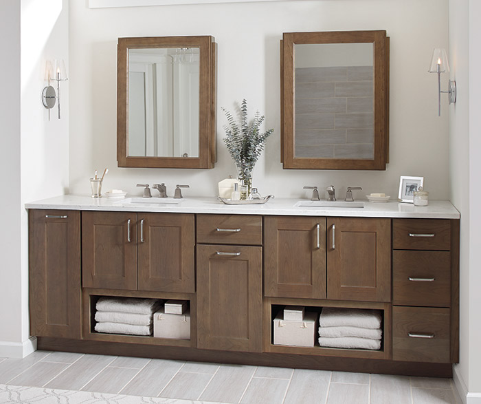 Bathroom counter with two sets of sinks, cabinets, and mirrors
