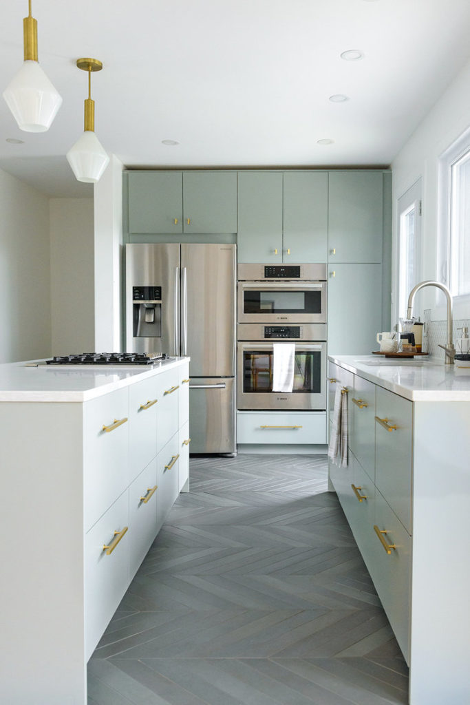 Kitchen with white counters, light green cabinets, and stainless steel appliances