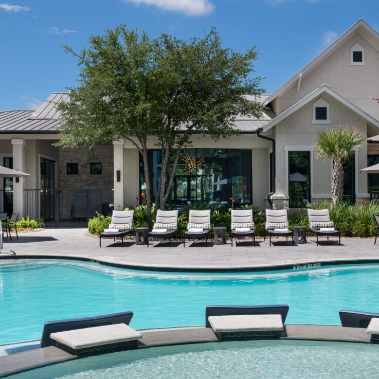 Outdoor pool with brown and white beach chairs