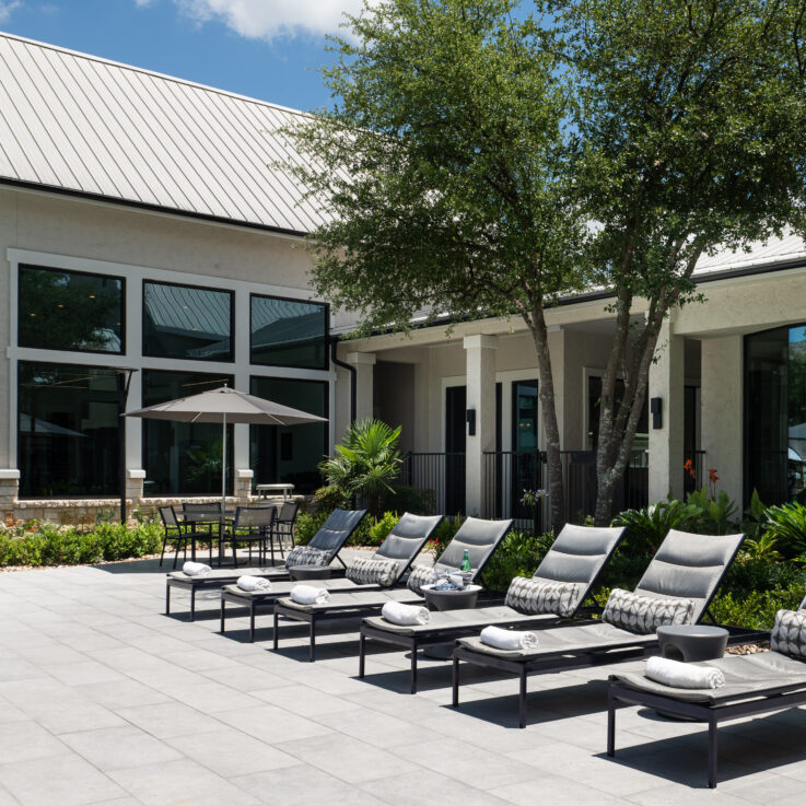 Beach chairs with brown and white pillows outside the clubhouse