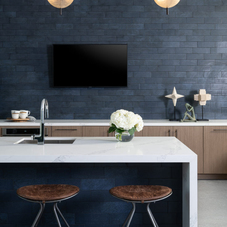 Kitchen area with white countertops and blue wall tiles