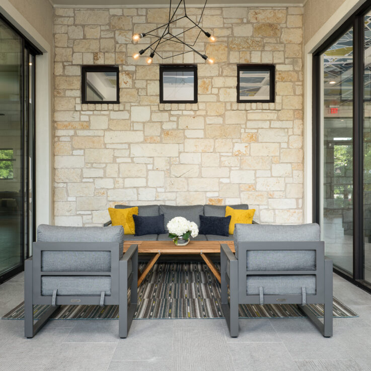 Gray couch and chairs, wooden coffee table, and sliding glass doors