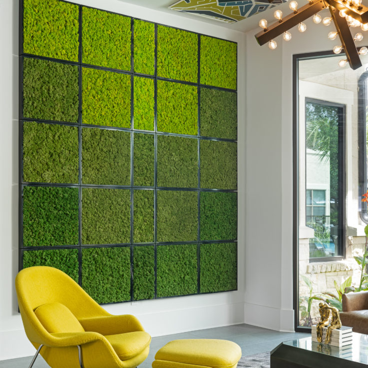 Yellow chair in front of green wall art