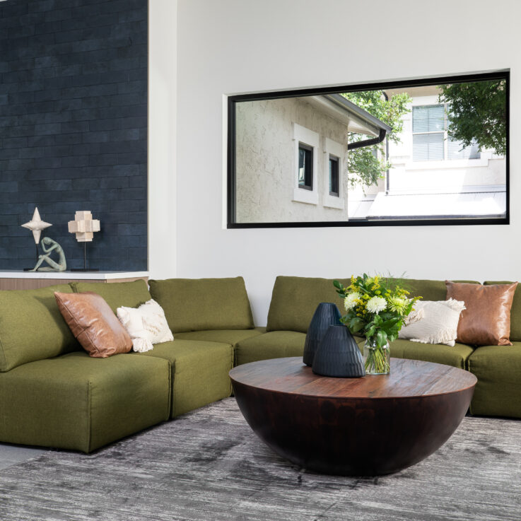 Green curved couches and a brown circular coffee table