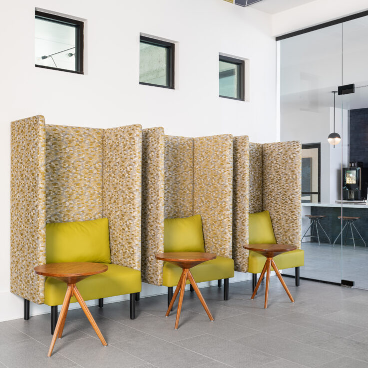 Three privacy chairs with three circular wooden tables