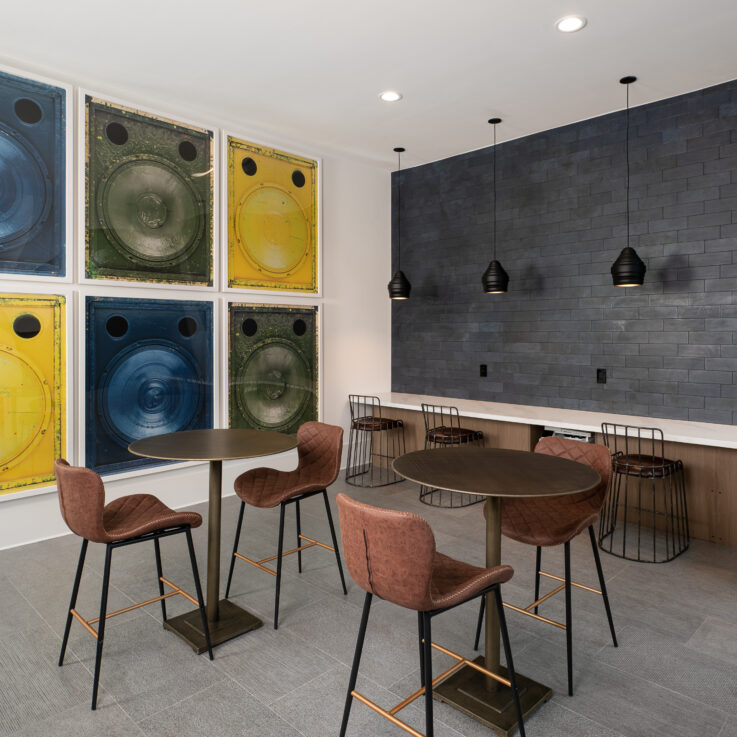 Seating area with brown tables and chairs and a dark blue tiled wall