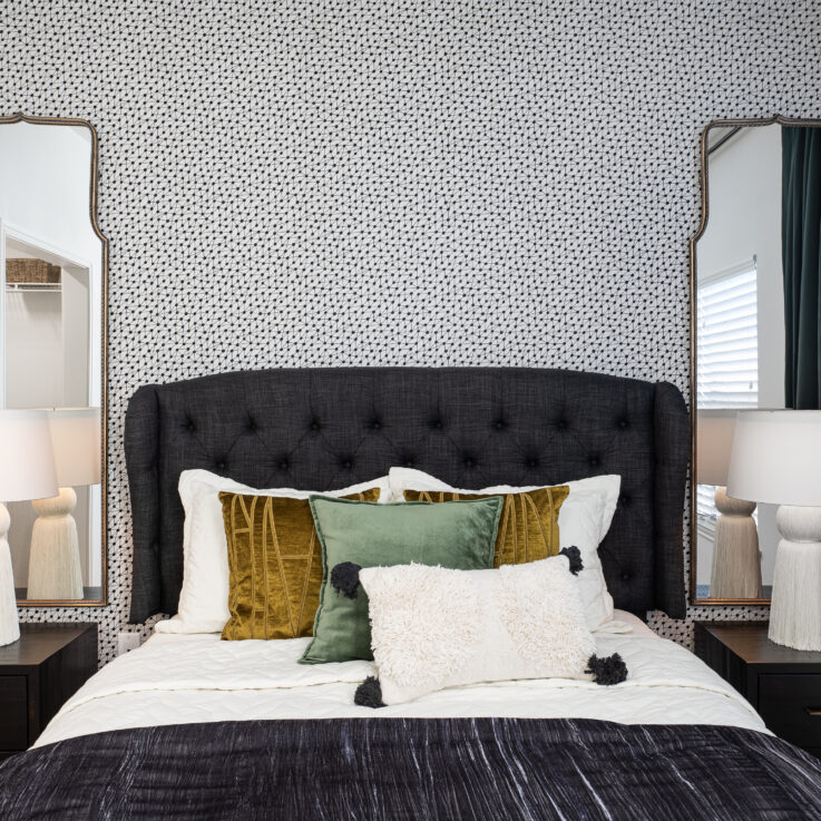 Bed with black headboard, two nightstands, and two mirrors