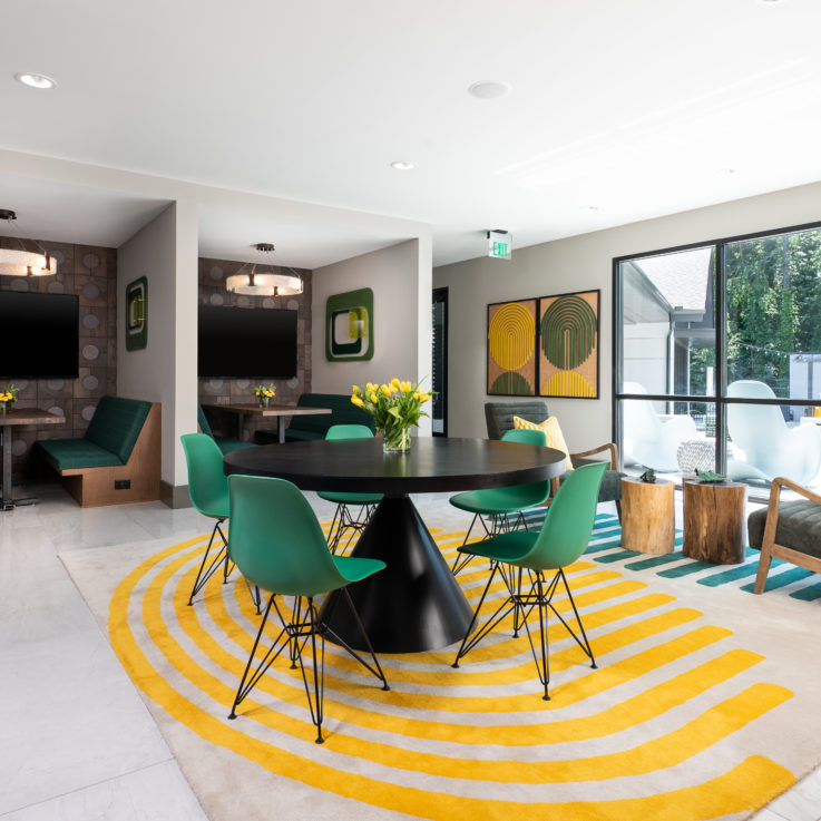 Dining area with benches, green chairs, tables, and large flatscreen televisions