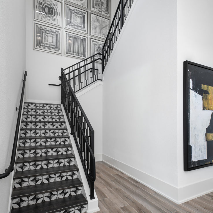 Black and white stairwell with nine pictures on the wall