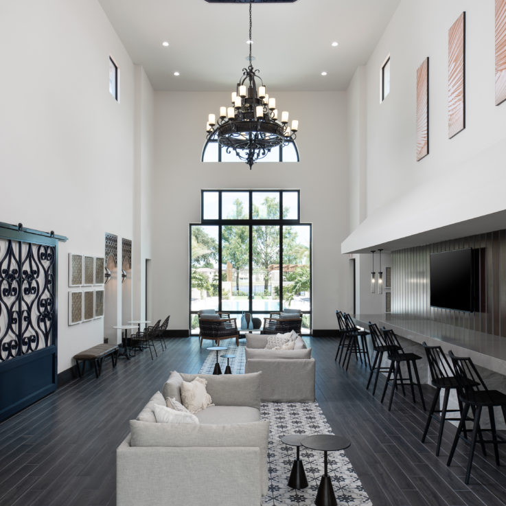 Common area with white couches and black barstools
