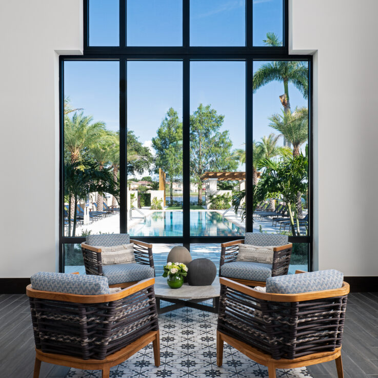 Four chairs around a circular coffee table in front of a window