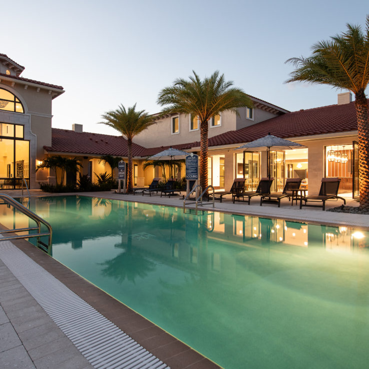 Outdoor pool with beach chairs and clubhouse