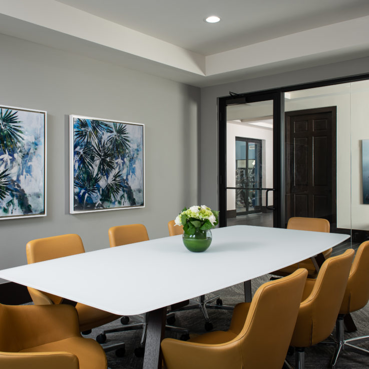 Conference room with a white table and eight orange chairs