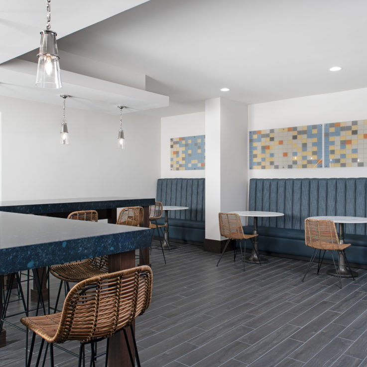 Dining area with wicker chairs, blue and white tables, and blue benches