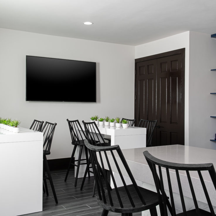 White tables with black chairs and dark blue cabinets