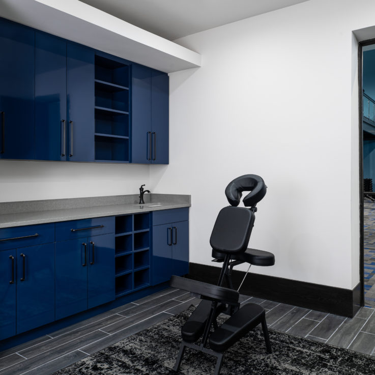 Massage room with blue cabinets and gray countertops