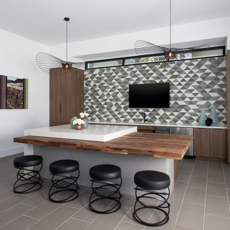 Wooden table with black stools in front of a flatscreen television