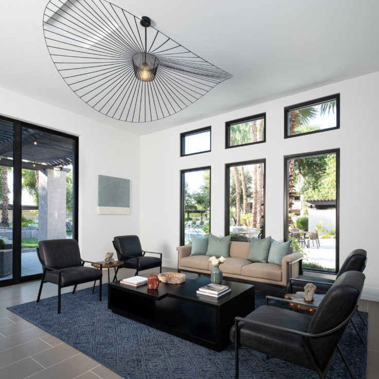 Seating area with dark blue carpet, black chairs, and a black coffee table