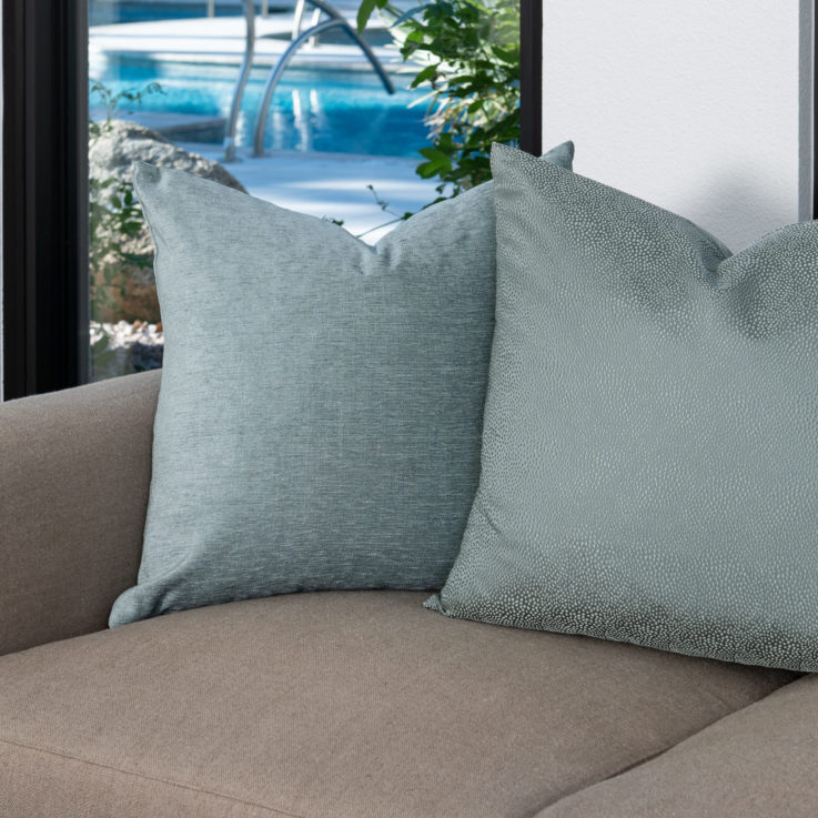 Beige couch with two teal pillows