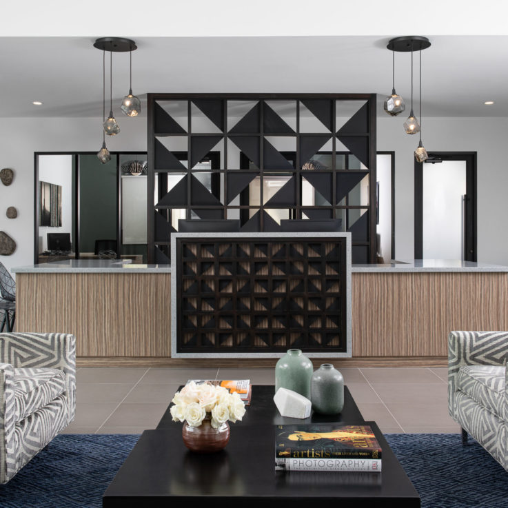 Seating area with a dark blue carpet and black art sculptures