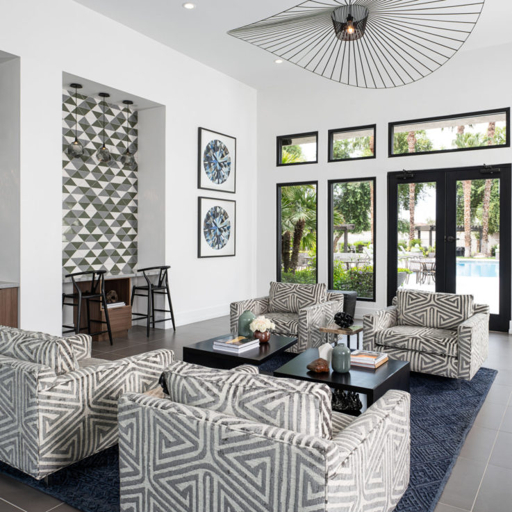 Seating area with white and black chairs and a blue carpet