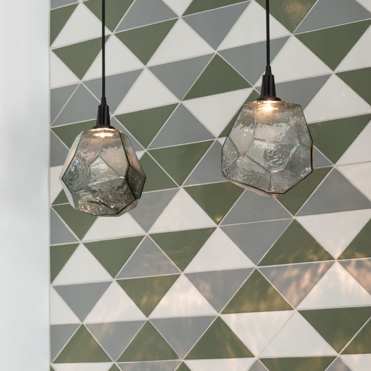 Haning lights in front of white, green, and blue tiles