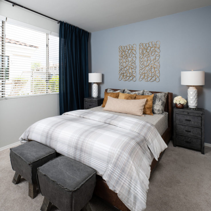 Queen bed with two bedside tables and a light blue wall