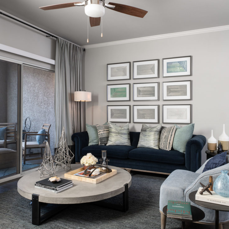 Seating area with a wooden floor and blue couches and chairs