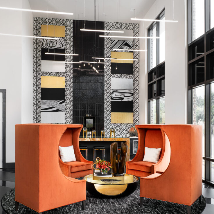 Four orange chairs around a glass coffee table in front of a coffee bar