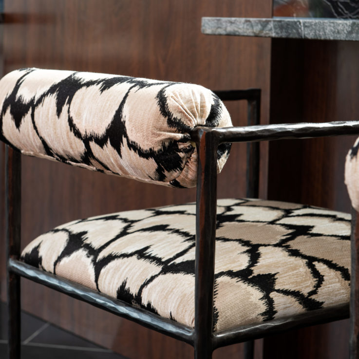 Wooden chair with beige and black patterned cushions