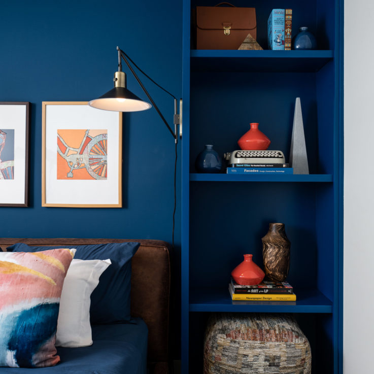 Blue bedside shelving with a clamp light