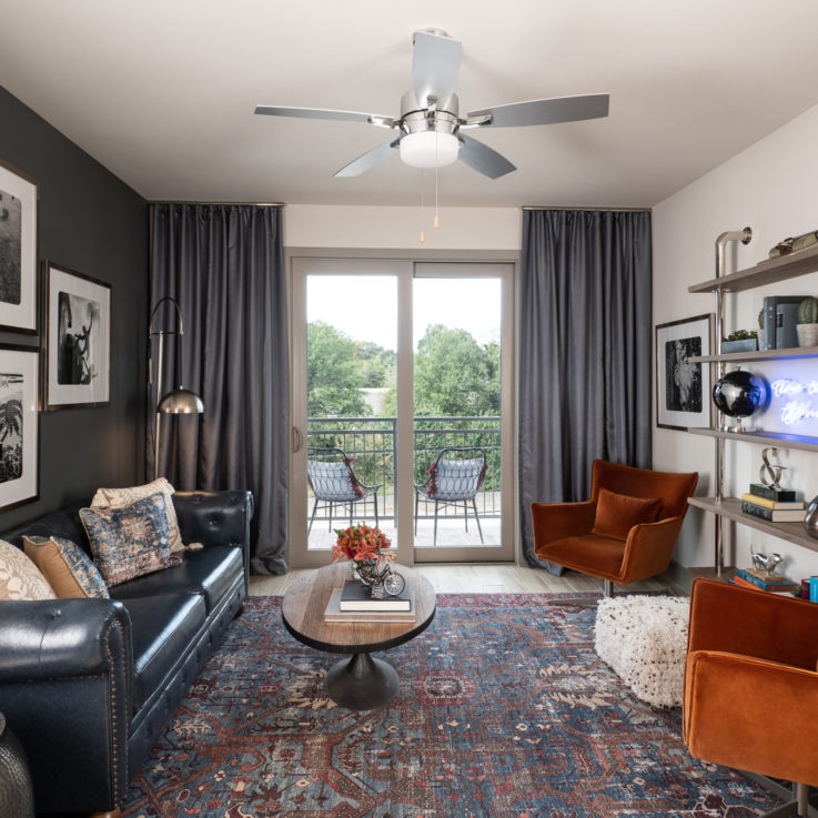 Seating area with a dark blue leather couch and two orange chairs