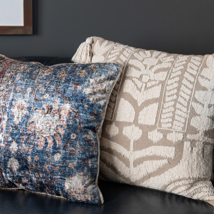 Two pillows on a dark blue leather couch